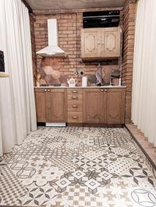 第比利斯Old Tbilisi style Apartment的厨房配有木制橱柜和瓷砖地板。