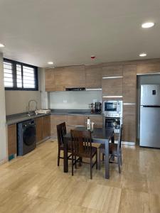 OtinshiにあるKnightsbridge Apartment K10のテーブルと椅子と冷蔵庫のあるキッチン