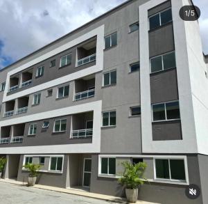 an apartment building with trees in front of it at Cantinho da paz in Fortaleza