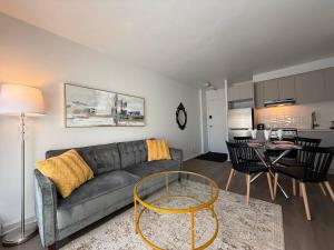 a living room with a gray couch and a table at McGill Les petits studios in Montréal