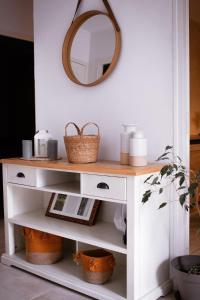 a dressing table with a mirror and baskets on it at La Vernoisienne dans le Jura in Le Vernois