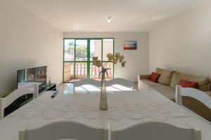 a living room with a table with a vase on it at Central, Barato e Espaçoso in Maringá