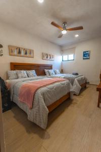 a bedroom with two beds and a ceiling fan at Villas Manglar Sisal 3 by WoWay Experiences in Sisal