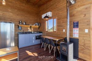a kitchen with a woodburning stove in a cabin at Cabana c/ vista panorâmica e jacuzzi - VST026 in São Paulo dos Pinhais