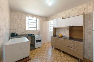 a kitchen with a stove and a sink in it at Central, Barato e Espaçoso in Maringá