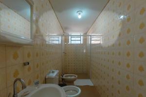 a bathroom with a sink and a toilet at Central, Barato e Espaçoso in Maringá