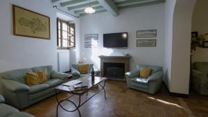 Una sala de estar con sofás, una mesa y un televisor. en Villa Storica Volterra, en Volterra