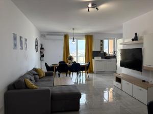 a living room with a couch and a dining room at Modern one bedroom Apartment in Żurrieq