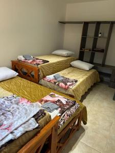 eine Gruppe von 3 Betten in einem Zimmer in der Unterkunft Aranduroga country club in Corrientes