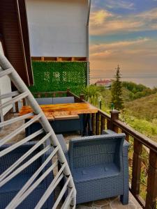 Una terraza con sillas y una mesa de madera en un balcón. en Willa's Trebisonda Bungalov, en Arsin