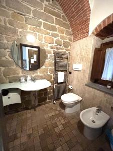 Baño de piedra con lavabo y aseo en Suite King- La Corte del Re Suite Rooms, en Arezzo