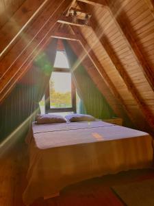 una cama en una habitación con ventana en Willa's Trebisonda Bungalov, en Arsin