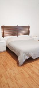 Cama blanca grande en habitación con suelo de madera en DOLCI SOGNI ROMANI SENZA SCALE O BARRIERE, en Roma