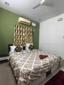 a bedroom with a bed with a comforter on it at SK INN stays in Mahabalipuram