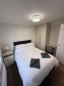 ein Schlafzimmer mit einem großen weißen Bett und zwei Kissen darauf in der Unterkunft Luxury townhouse in Stirling in Stirling