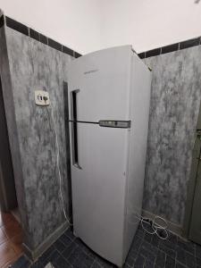 a white refrigerator in a kitchen next to a wall at Great central apartment in Duque de Caxias +8 photos