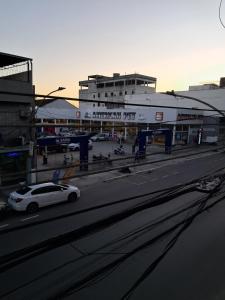 a white car parked in front of a gas station at Great central apartment in Duque de Caxias