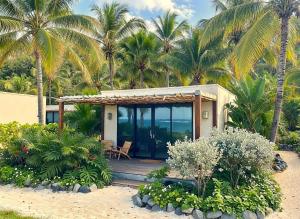 MayreauWindward Mayreau Resort的棕榈树海滩上的房子