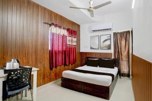 ein Schlafzimmer mit Bett, Schreibtisch und Fenster in der Unterkunft Super Hotel O Dr. Babasaheb Ambedkar International Airport Formerly Infinity Inn in Dhantoli