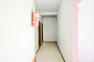 einen Flur mit weißen Wänden und weißem Fliesenboden in der Unterkunft Super Hotel O Dr. Babasaheb Ambedkar International Airport Formerly Infinity Inn in Dhantoli