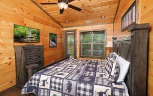 a bedroom in a cabin with a bed and a ceiling fan at Beary Relaxed in Sevierville +87 photos