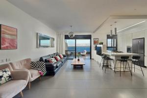 a living room with a couch and a table and a kitchen at Levication Tiberias Luxury Private Pool Apartments in Tiberias