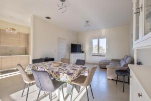 a kitchen and living room with a table and chairs at Villa Corbezzolo in Galatone