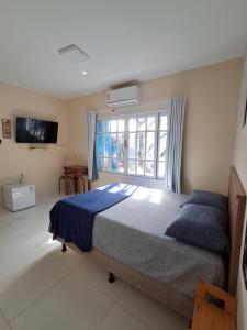 コンデにあるPousada Odoyá Beach - Casalの大きなベッドと窓のある寝室