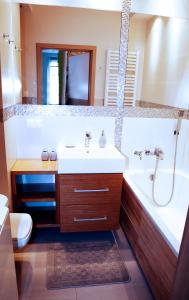 y baño con lavabo, bañera y aseo. en Apartament Teresa w Uniejowie, en Uniejów