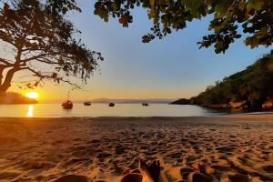 Praia do BananalCasa de Temporada Ceu e Mar的日落时躺在海滩上的人