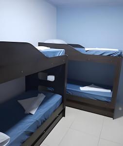 two bunk beds in a room with blue sheets at Casa de Temporada Ceu e Mar in Praia do Bananal