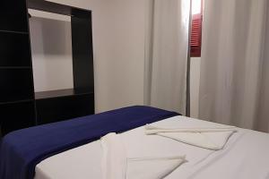 a white bed with a blue blanket and a mirror at Casa de Temporada Ceu e Mar in Praia do Bananal +28 photos