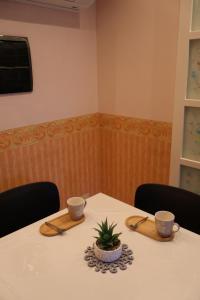 a table with two cups and a plant on it at Maison Prestige in Monfalcone +10 photos