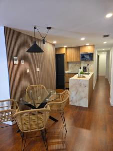 a kitchen and dining room with a glass table and chairs at Solsuites in Almería +15 photos