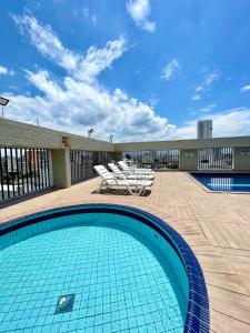 a swimming pool with lounge chairs on a patio at Skyblue Flat in São Vicente