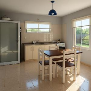 eine Küche mit einem Holztisch und Stühlen darin in der Unterkunft Latitud 44 in Mar Azul