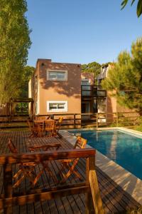 eine Terrasse mit Tisch und Stühlen neben einem Swimmingpool in der Unterkunft Latitud 44 in Mar Azul