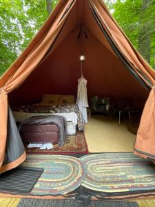 a bedroom in a tent with a bed and a rug at Romantic Botanical Bell Tent for a Fantastic Glamping Experience in Southbury, Connecticut in Southbury