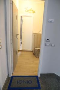 a hallway with a door into a room with a welcome mat at Domus Marina - Ionio room in Mondragone +45 photos