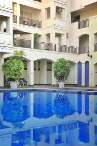 a swimming pool in front of a building at Luxury Pool view Apartment w Jacuzzi by Mirabella in Mapusa