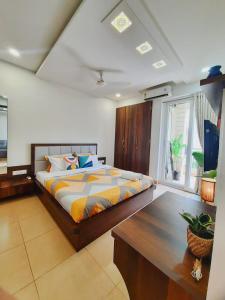 a bedroom with a large bed and a table at Luxury Pool view Apartment w Jacuzzi by Mirabella in Mapusa