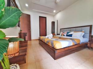 a bedroom with a large bed in a room at Luxury Pool view Apartment w Jacuzzi by Mirabella in Mapusa