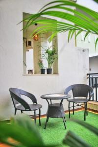 a patio with two chairs and a table and two chairs at Luxury Pool view Apartment w Jacuzzi by Mirabella in Mapusa