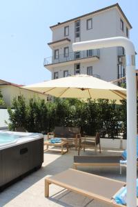 a patio with a table and an umbrella and a pool at Domus Marina - Ionio room in Mondragone