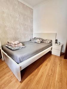 Una cama grande en una habitación con suelo de madera. en OMG Faro, en Faro