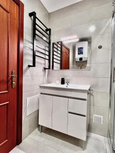 Un baño con un lavabo blanco y un espejo. en OMG Faro, en Faro