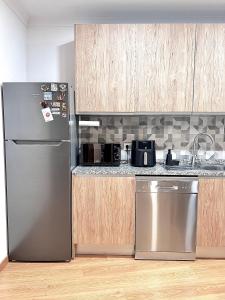 Una cocina con refrigerador de acero inoxidable y gabinetes de madera. en OMG Faro, en Faro