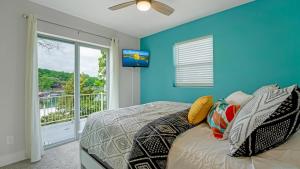 a blue bedroom with a bed and a sliding glass door at Amazing Lakefront Paradise with Perfect Location in Osage Beach