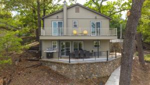 a large house with a porch and a deck at Amazing Lakefront Paradise with Perfect Location in Osage Beach