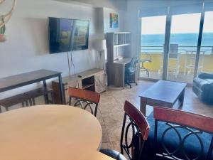 een woonkamer met een tafel en stoelen en de oceaan bij Ocean Walk Resort - Remarkable Ocean Front View in Daytona Beach